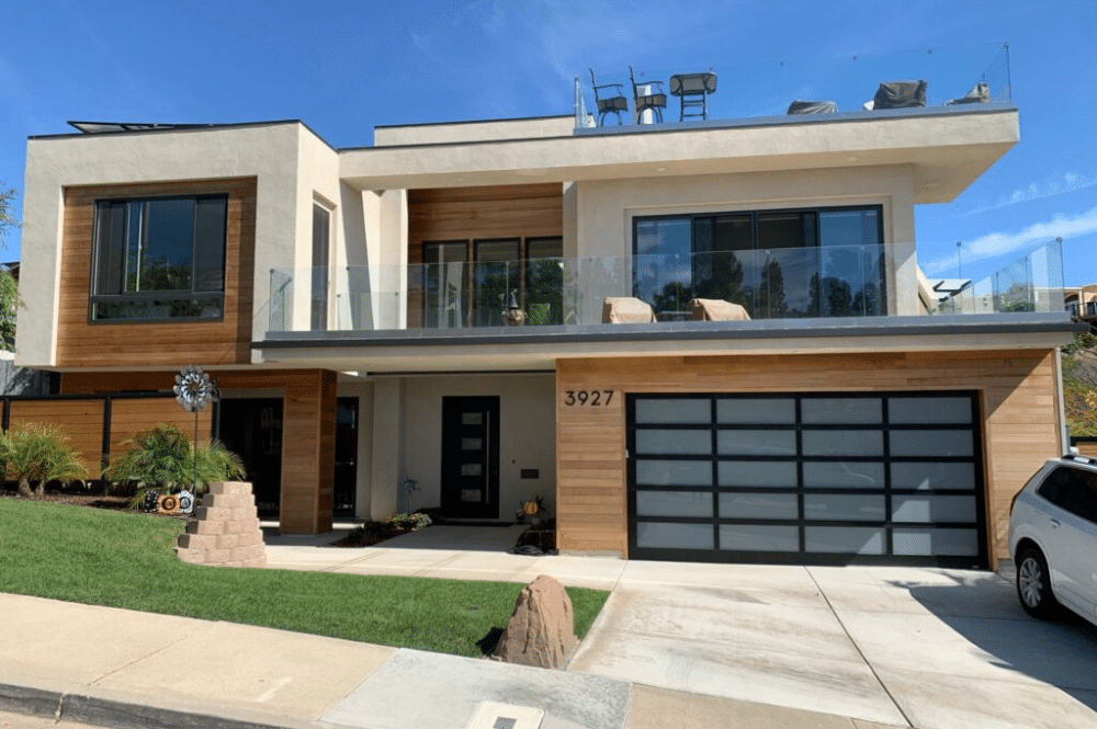 A modern home featuring a stylish garage door and a spacious driveway, showcasing excellent curb appeal.