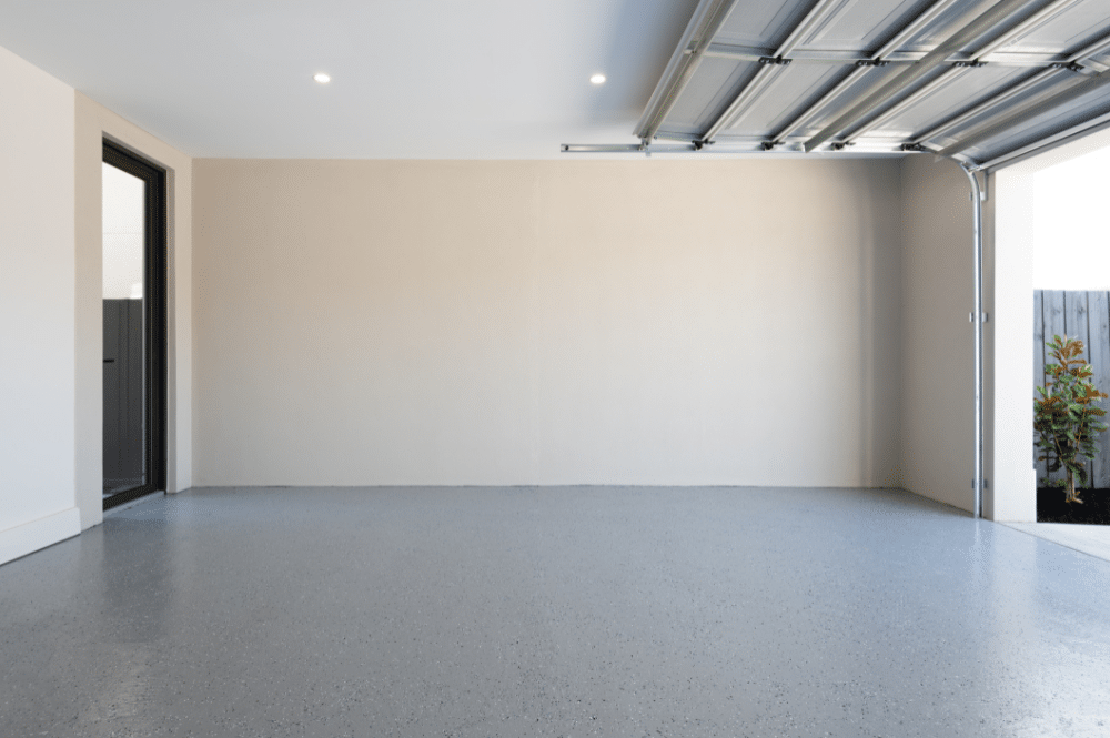 An empty garage with an open door, indicating the garage door is unable to close properly.