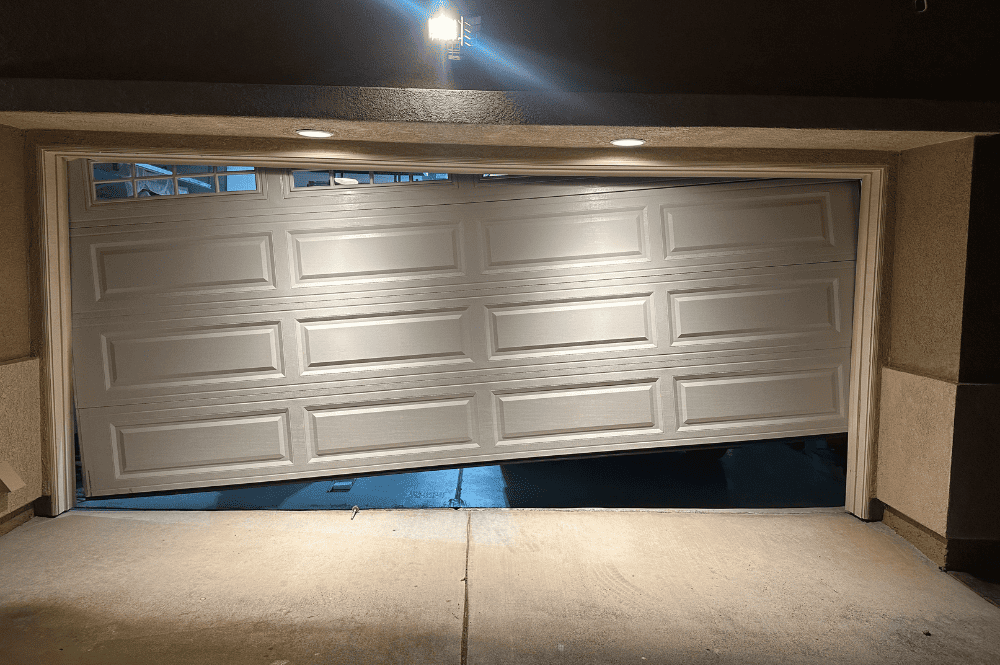 An open garage door at night, with visible garage door spring repair signs.